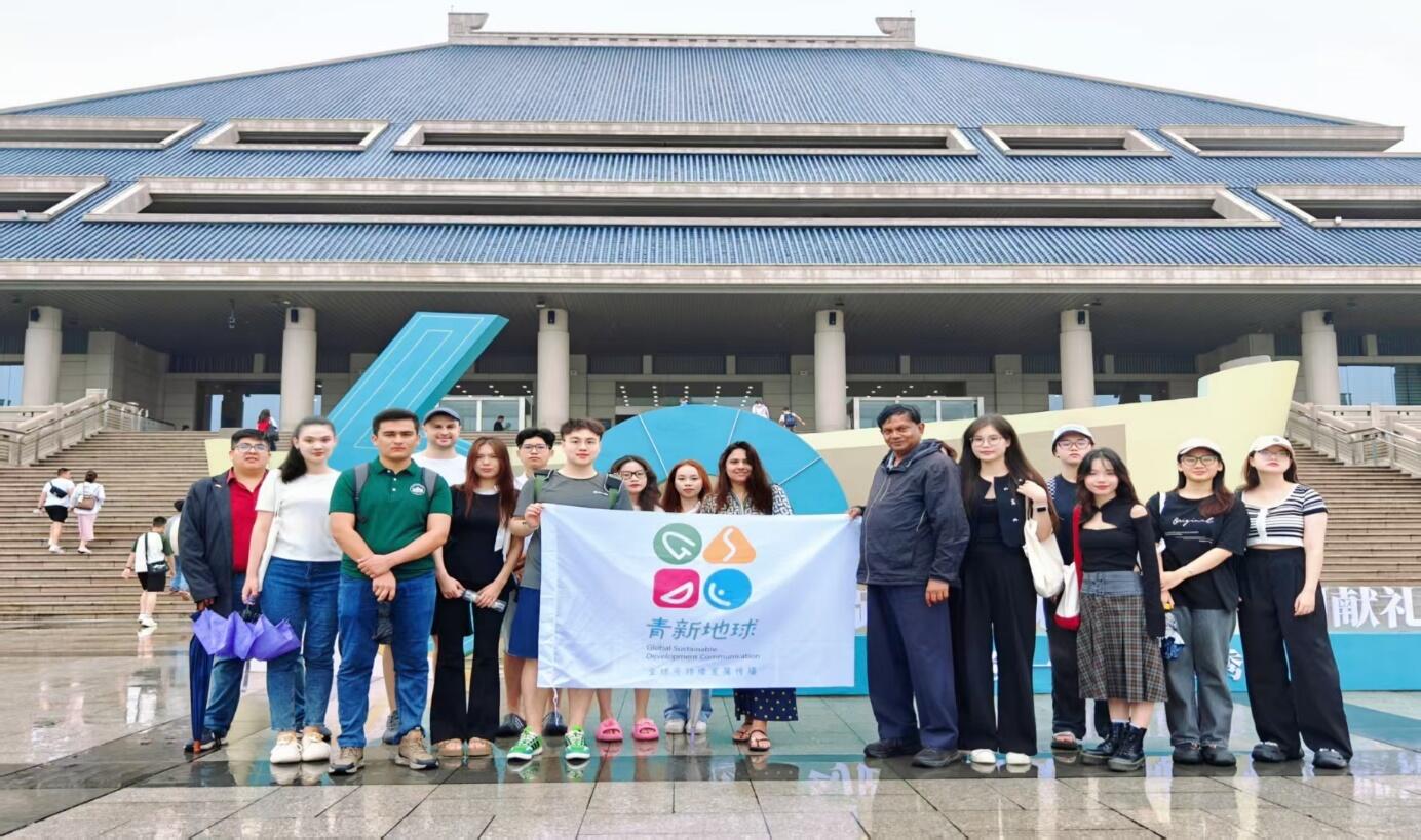 A group of people posing for a photo in front of a building
Description automatically generated