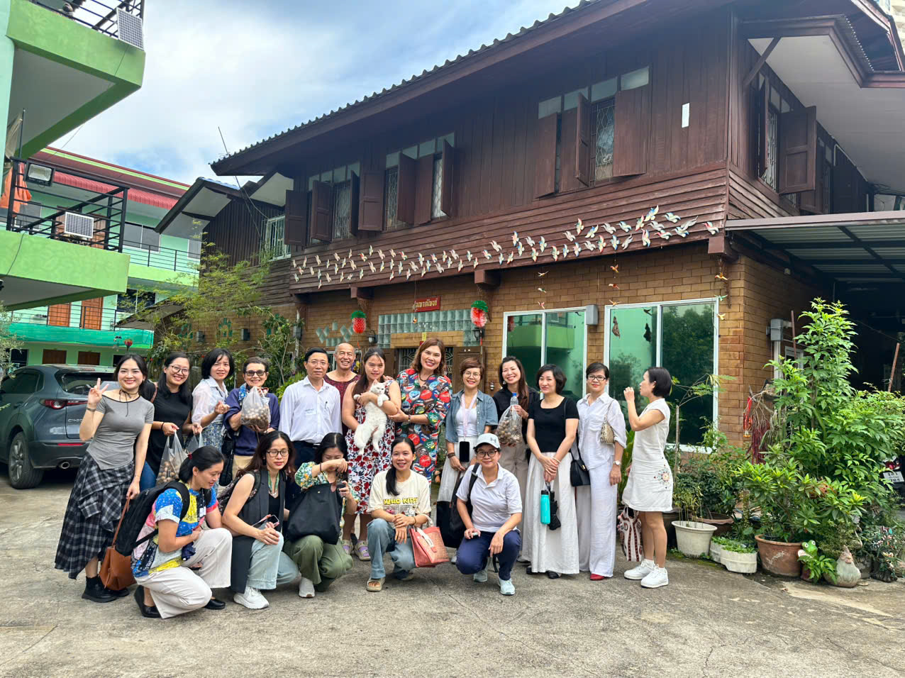 A group of people posing for a photo in front of a house Description automatically generated