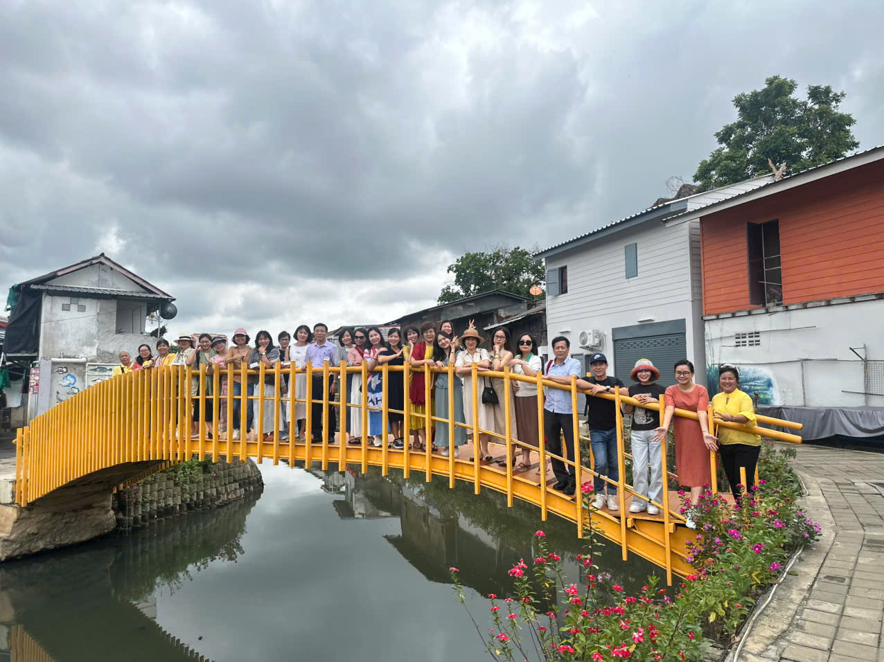 A group of people standing on a bridge over water Description automatically generated