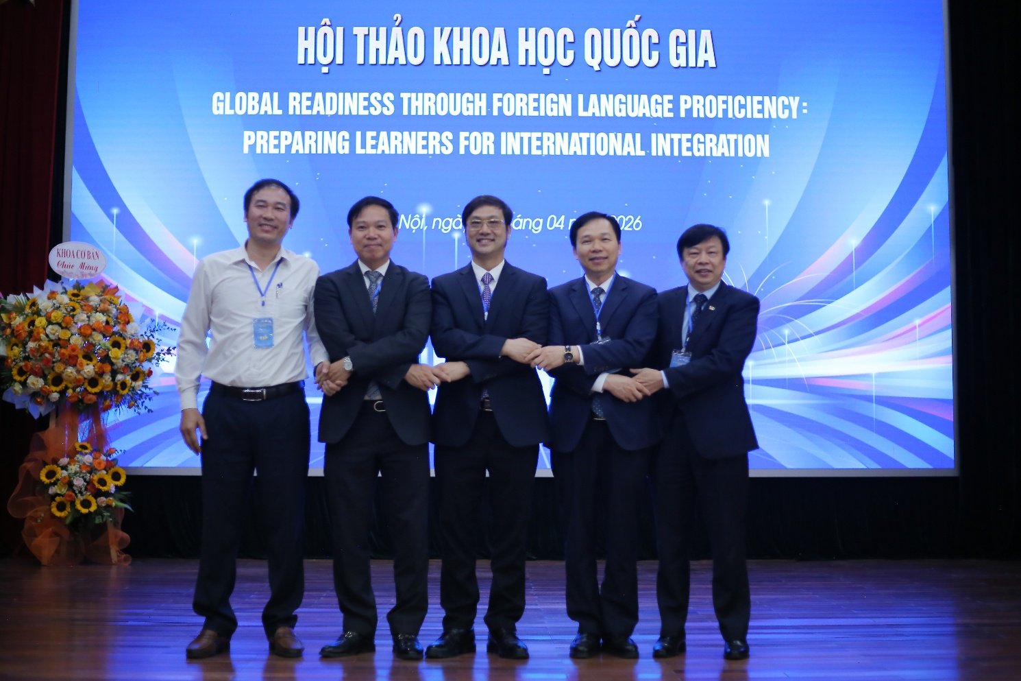 A group of men standing in front of a screen Description automatically generated