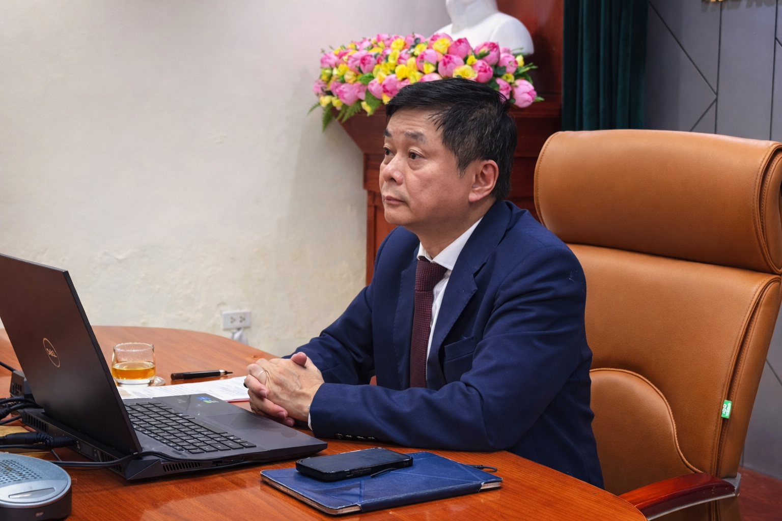 A person sitting at a desk with a computer
Description automatically generated
