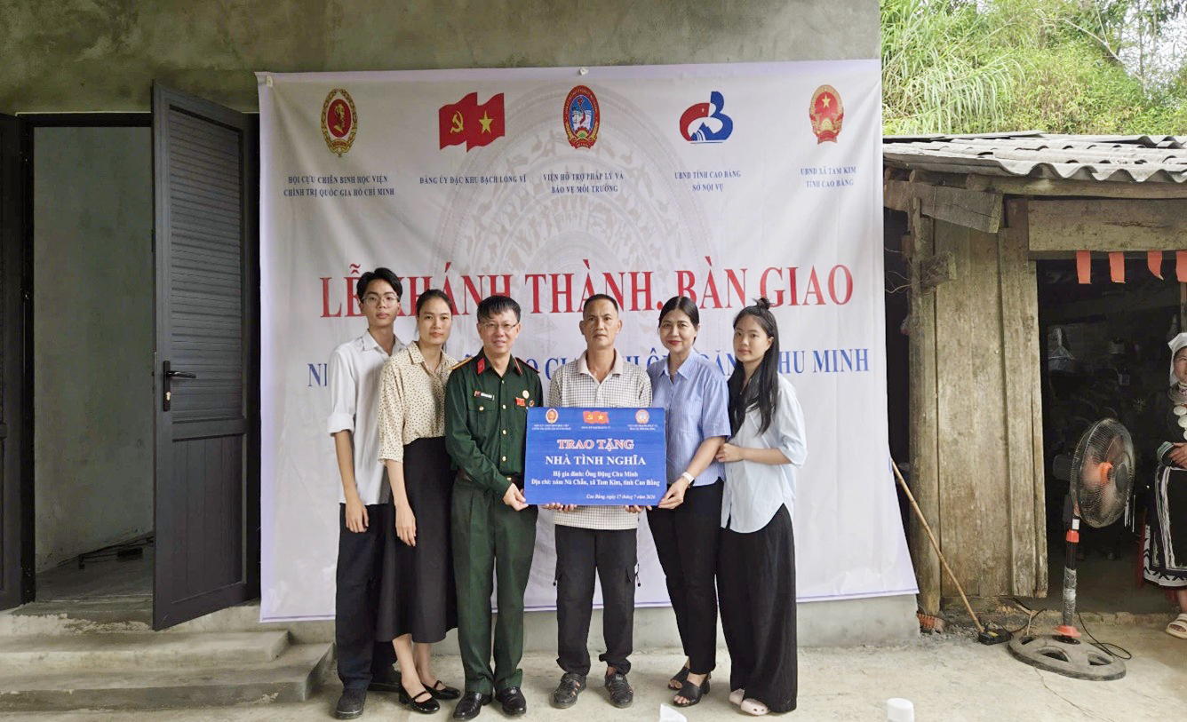 A group of people standing in front of a banner Description automatically generated