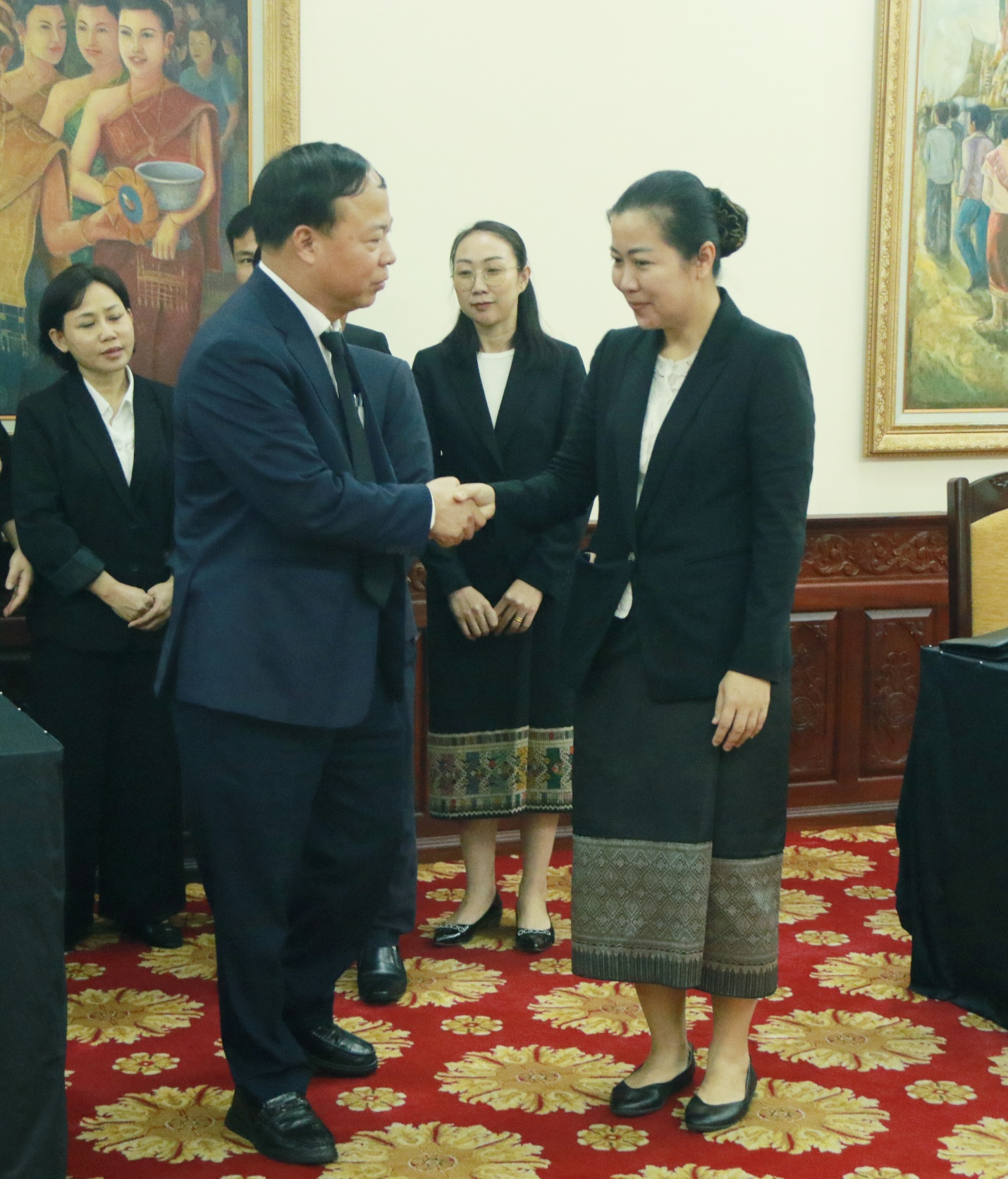 A person and person shaking hands Description automatically generated