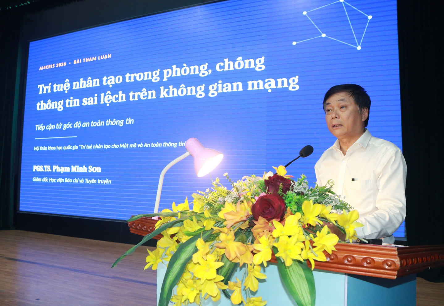 A person standing at a podium with a microphone Description automatically generated